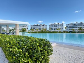 Ein Resort mit Schwimmbad, Palmen und modernen Gebäuden.