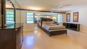 Ein Schlafzimmer mit Bett, Kommode und Deckenventilator.