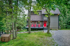 A two-story building with a porch and red chairs. - Bearfoot Beech - Game table, fire pit, private hot tub! (Banner Elk)