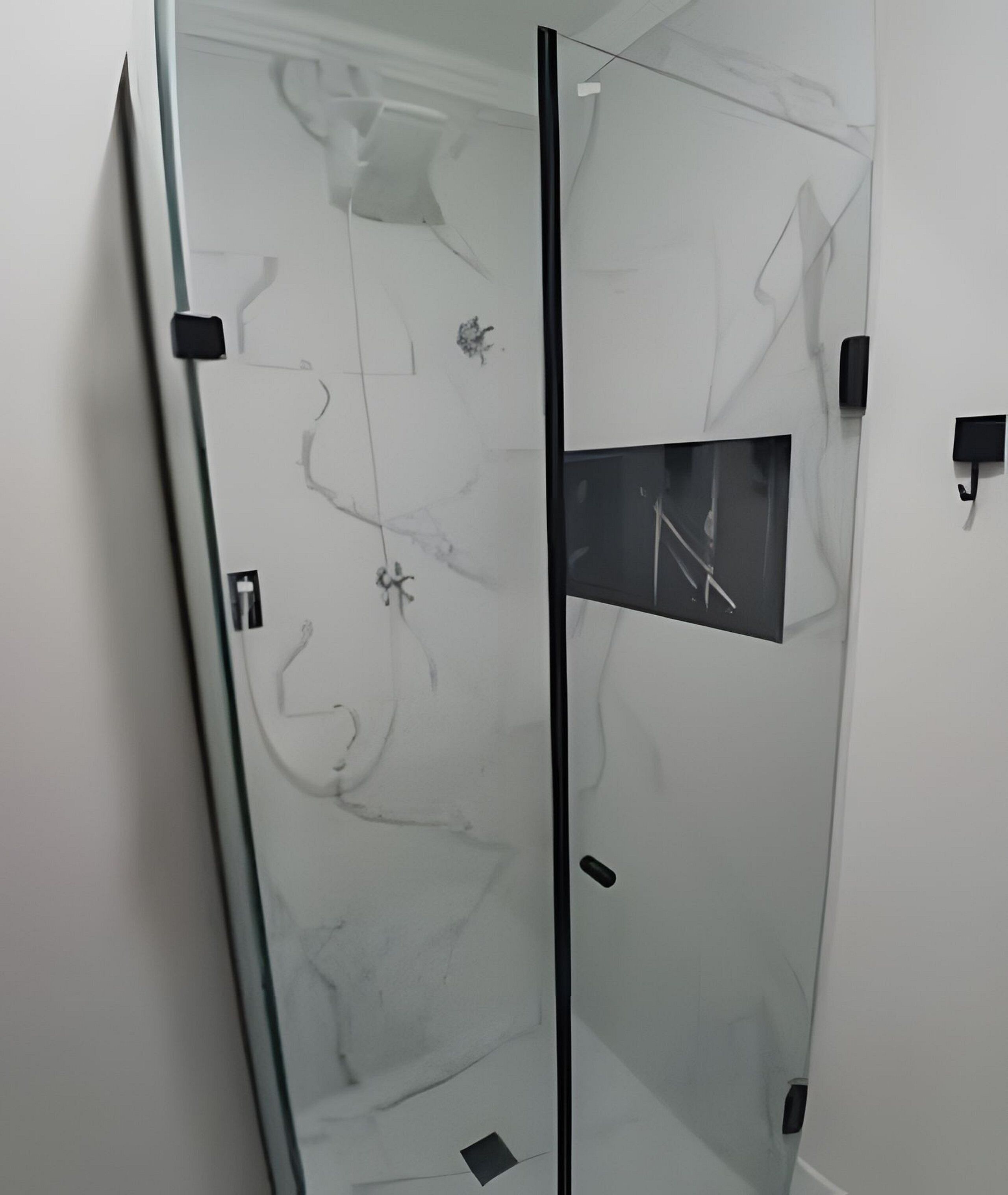 Une cloison en verre avec une petite fenêtre, une porte et un panneau de commande fixé au mur.