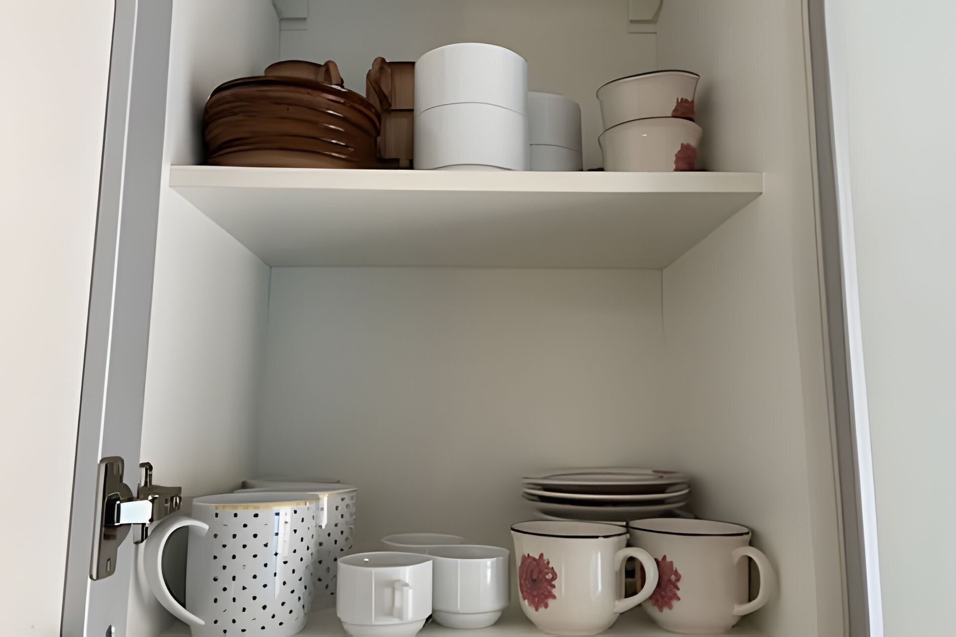 A storage area with shelves holding various kitchenware items.