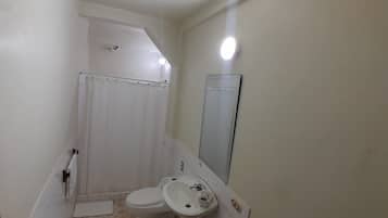 Un baño pequeño con inodoro, lavabo y ducha.