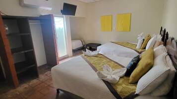 Une chambre d’hôtel avec un lit, une télévision, une armoire et une fenêtre.