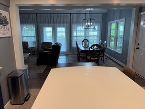A dining area with a table and chairs, a sofa, and a chandelier.