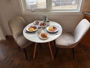 Une table de petit-déjeuner avec des assiettes remplies de nourriture, un thermos et une tasse.