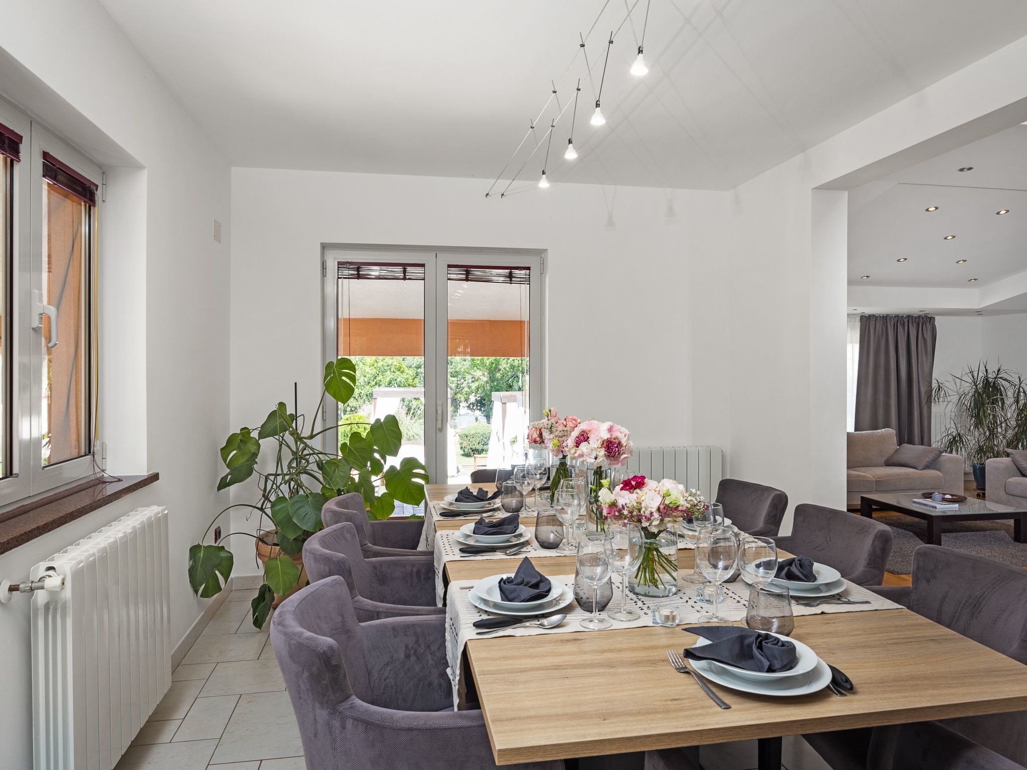 Un espace de restauration moderne avec une longue table dressée pour un repas, entourée de sièges confortables.