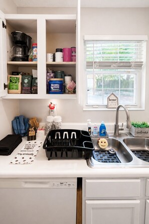 A kitchen with white cabinets, a coffee maker, and various kitchen items. - 3BR Near Downtown, Zoo Atlanta, & BeltLine (Atlanta)