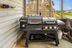 A portable grill with a handle and knobs, placed on a wooden deck. - Saltwater Sunrise: Ocean Views & Beach Access (Rodanthe)