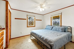 A bedroom with a bed, a ceiling fan, and two windows. - Saltwater Sunrise: Ocean Views & Beach Access (Rodanthe)