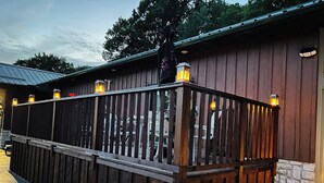 A wooden fence with lanterns, a stone wall, and a building with a metal roof. - High end 4-bedroom countryside home in Shawano, WI. 2,800 sqft and spacious! (Shawano)