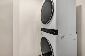 A stacked washer and dryer unit with a control panel and a label indicating it is a direct drive model. - Boulder Oasis - 3 Bed 2 Bath Home in Yucca Valley (Yucca Valley)