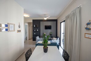 Un salon moderne avec une table à manger, une plante en pot et un téléviseur.