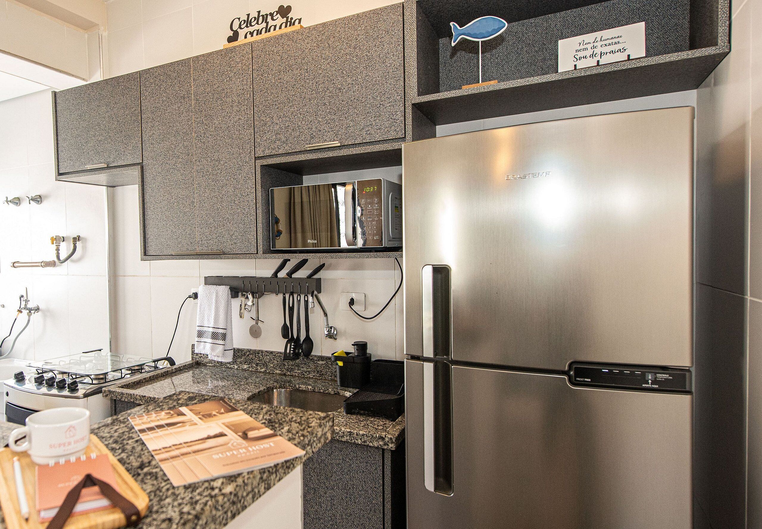 A kitchen with a stainless steel refrigerator, a microwave, and a gas stove.