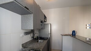 Una cocina moderna con estufa a gas, electrodomésticos de acero inoxidable y encimeras de granito.