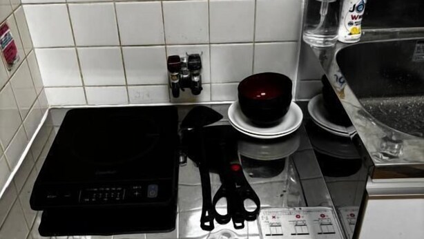 A kitchen with a stove, a microwave, and a sink.