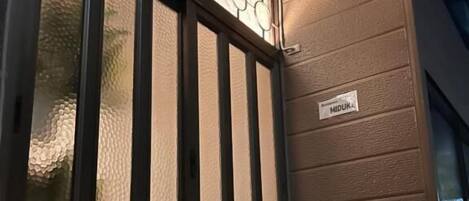 Uma porta com painel de vidro texturizado e uma placa com a inscrição 'MIDUK'.