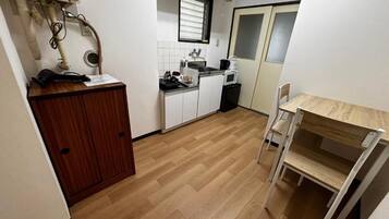 A compact kitchen with a microwave, sink, and wooden cabinets.