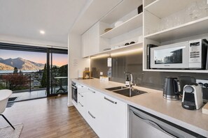 Una cocina moderna con lavavajillas integrado, cafetera y microondas.