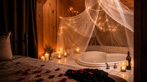Ein Schlafzimmer mit einem großen Bett, einer Badewanne und einem Baldachin mit Lichterketten.