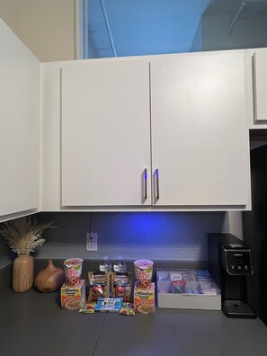 A kitchen with white cabinets, a coffee machine, and various food items on the counter. - NEW! Downtown Indianapolis with Direct Convention Center Access (Indianapolis)