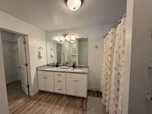 A bathroom with a double sink vanity, a mirror, a ceiling light, and a shower curtain. - The Point Retreat, Theater, Firepit, Near I-15 (Bluffdale)