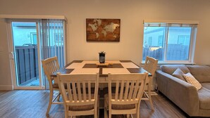 A dining area with a table and chairs, a sofa, and a world map artwork on the wall. - The Point Retreat, Theater, Firepit, Near I-15 (Bluffdale)