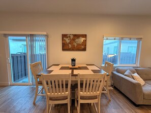 Ein Essbereich mit Tisch und Stühlen, einer Couch und einer Weltkarte als Wandbild.
