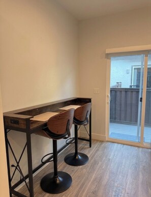 A kitchen with a bar area featuring two stools and a wooden table. - The Point Retreat, Theater, Firepit, Near I-15 (Bluffdale)
