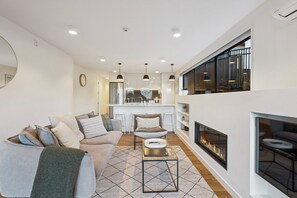 Ein modernes Wohnzimmer mit Sofa, Couchtisch und Kamin.