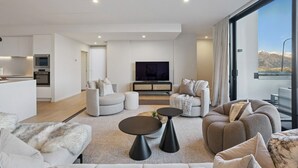 Een moderne woonkamer met een bank, een salontafel en een televisie.