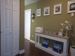 A hallway with a fireplace, a welcome sign, and framed pictures on the wall.