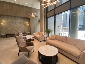 A modern lounge area with sofas, armchairs, and a coffee table. - Aqua Waterfront Resort (Kelowna)