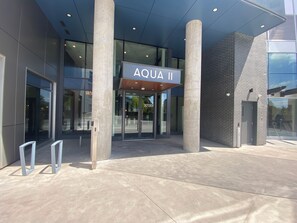 A modern building entrance with a sign reading 'AQUA II' and a glass door. - Aqua Waterfront Resort (Kelowna)