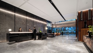 A modern hotel lobby with a reception desk, seating area, and large windows. - Intercity Shanghai Lujiazui Central (Shanghai)