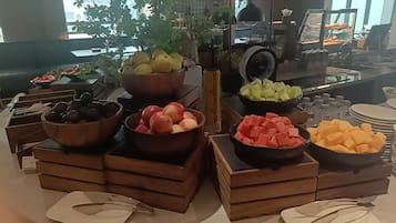 Een buffet met diverse soorten fruit en groenten in houten bakken.