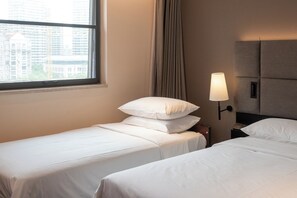 A hotel room with two beds, a window with a view of buildings, a lamp, and a curtain. - Intercity Shanghai Lujiazui Central (Shanghai)