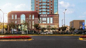 Un edificio de hotel alto con diseño moderno, que presenta una combinación de fachada de vidrio y ladrillo, y una señalización destacada para el Hotel Intercity.