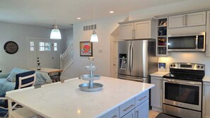 A modern kitchen with stainless steel appliances, a marble countertop, and pendant lighting. - Downtown Harbor Springs cottage with 4 bedrooms, 2 baths, yard, and grill. (Harbor Springs)
