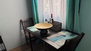 A dining area with a table, chairs, a bowl, and a basket. - Butterfly Cove (Lead Vale)