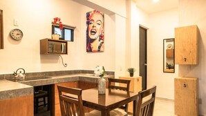 Eine moderne Küche mit Essbereich, Holzschränken, einer Mikrowelle und einem großen Gemälde an der Wand.