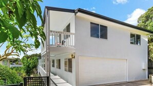 A two-story residential building with a white exterior, a balcony on the upper floor, and a garage. - Rye beach getaway (Rye)