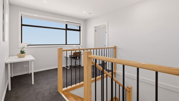 A modern interior with a staircase, a desk with a chair, and a large window. - Domi Rentals - The Ormond House (Clayton)