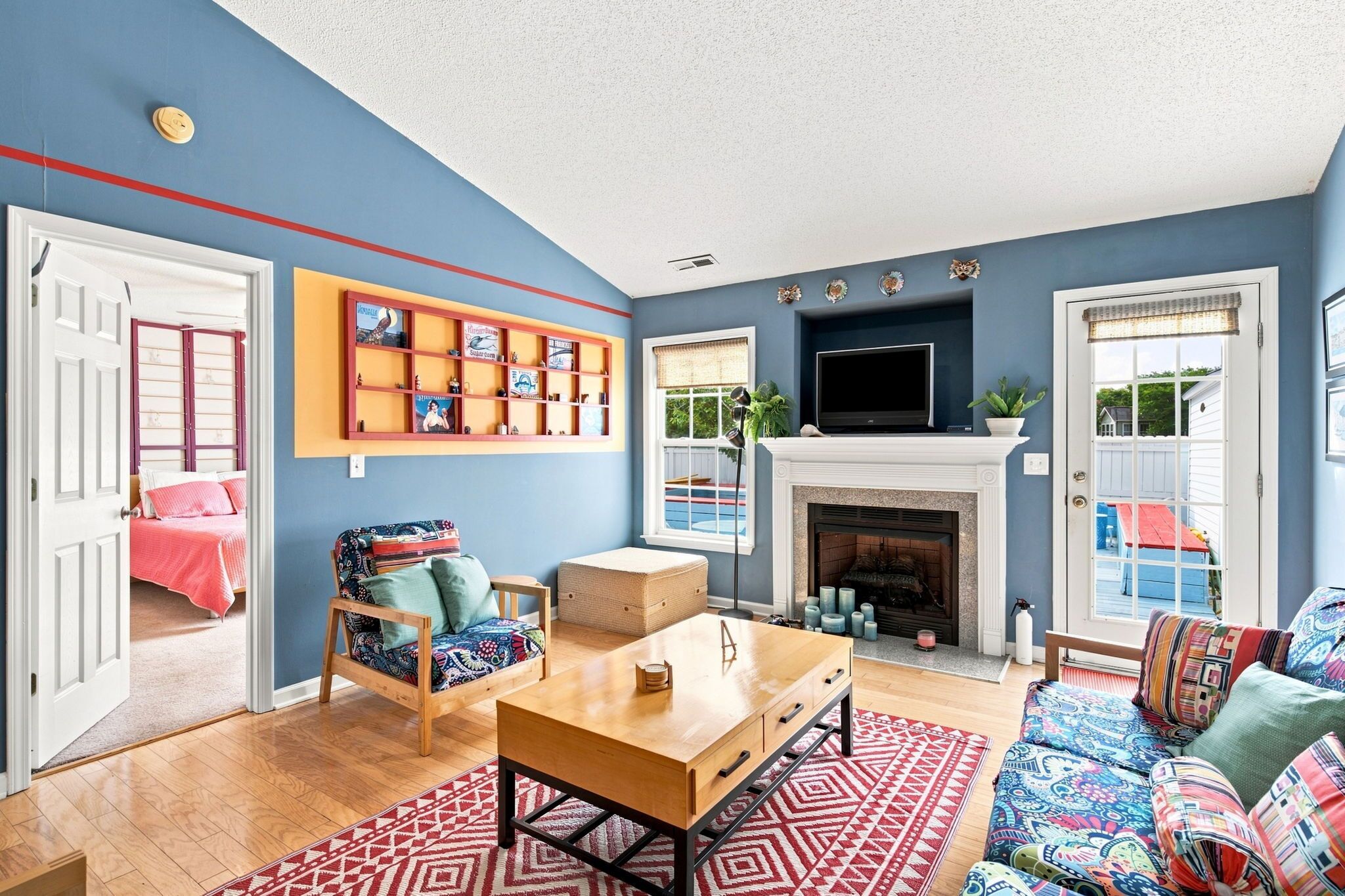A living room with a fireplace, a bookshelf, a sofa, and a chair.