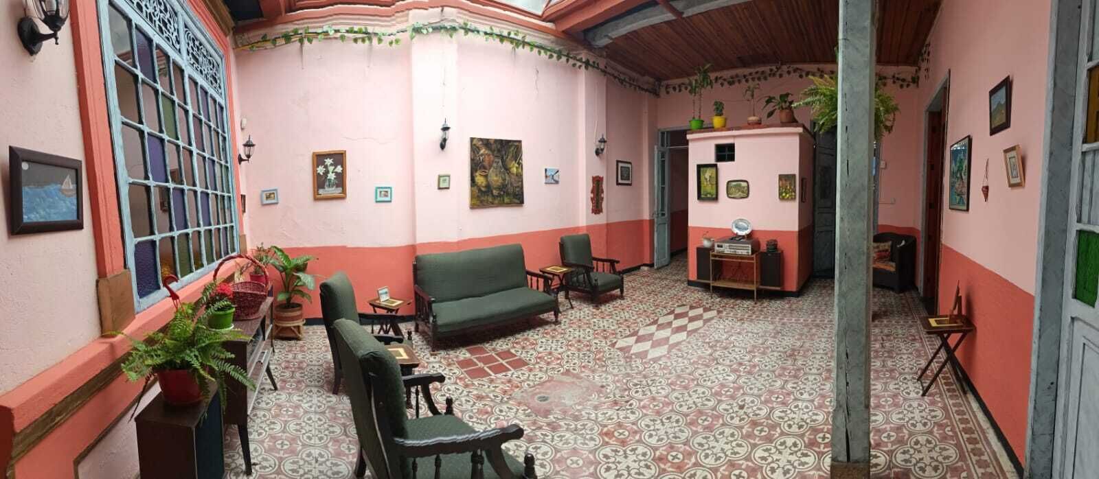 A room with a checkered floor, a sofa, chairs, a small table, and a potted plant.