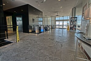 Eine großzügige Lobby mit hoher Decke, einem Glaselevator und einem großen Fenster mit Blick.