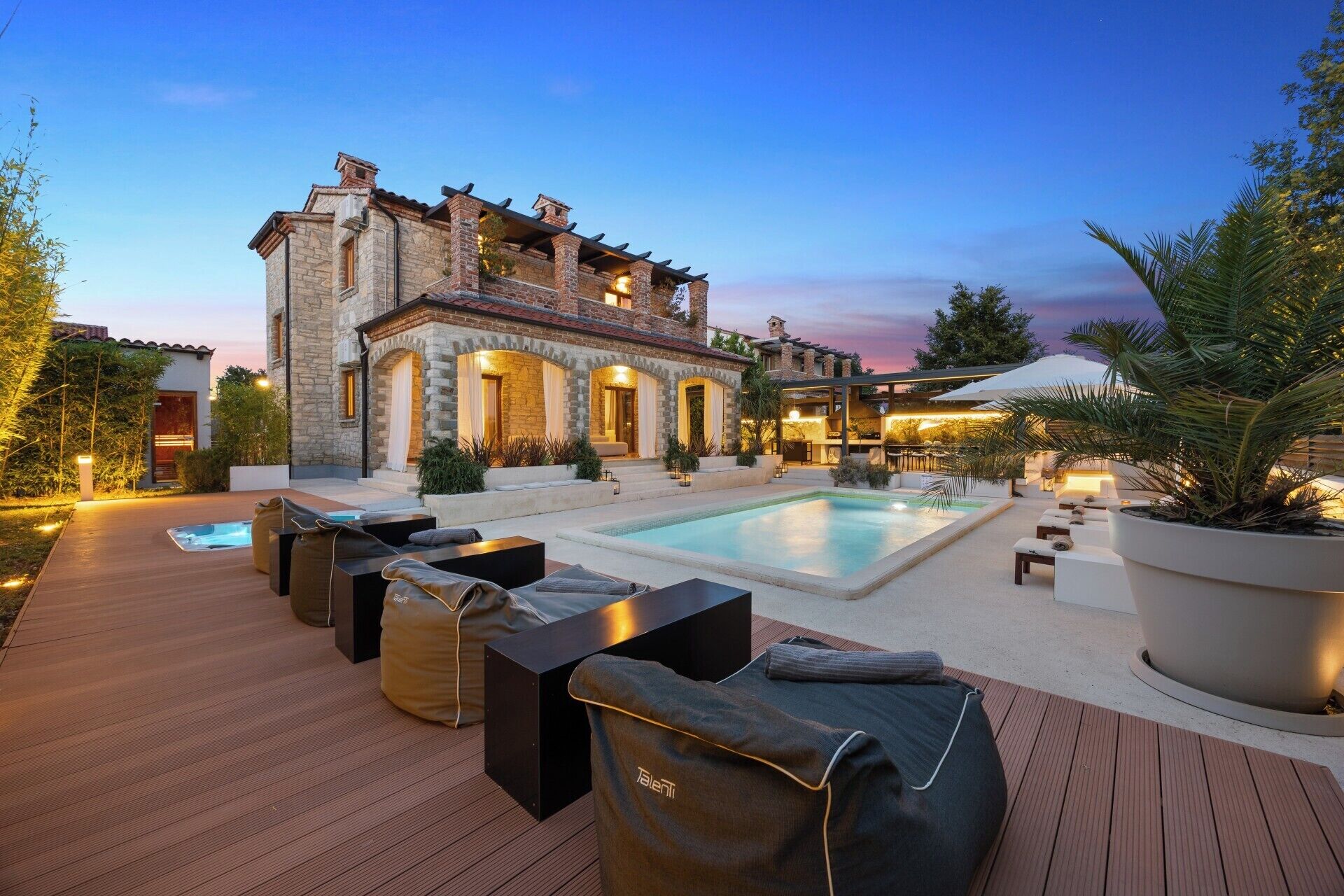 A poolside area with lounge chairs and a stone building in the background.
