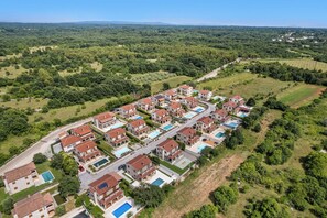 An aerial view of a residential area with multiple houses, roads, and green spaces. - Villa Aurelia – Luxury Istrian Stone Villa with Pool, Jacuzzi and Sauna by Istrabook (Čabrunići)