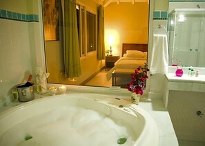A hotel bathroom with a large bathtub, a shower, and a vanity. - Ferradura Parque Pousada (Búzios)