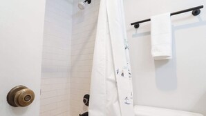 A bathroom with a white toilet, a shower curtain, and a towel rack. - Fireside Suite, Simple Basecamp at Snowline Lodge (Deming)