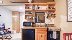 A compact kitchen with wooden cabinetry, a microwave, a stove, and a refrigerator. - Fireside Suite, Simple Basecamp at Snowline Lodge (Deming)